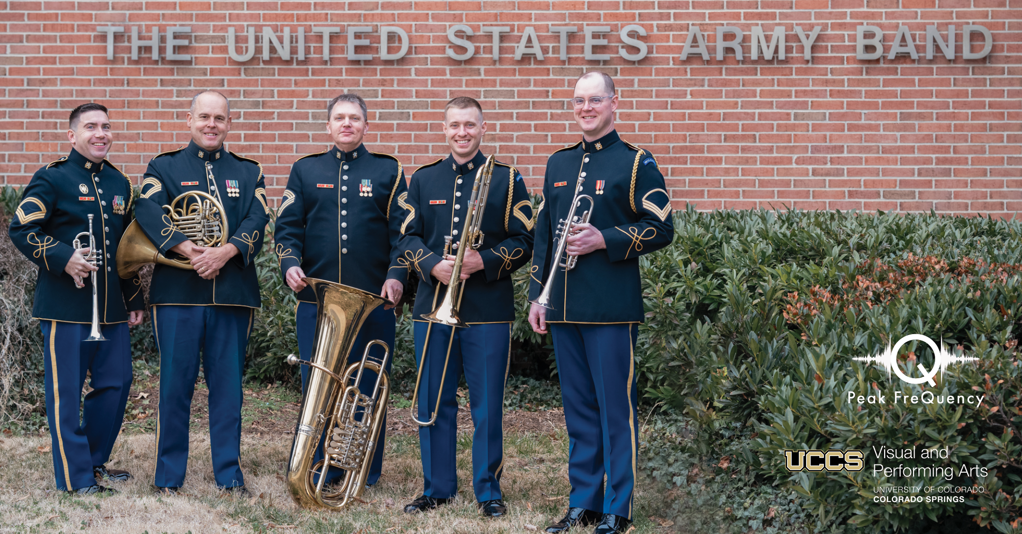 photo of quintet in uniform standig in front of a brick wall with a sign that reads "The United States Army Band"
