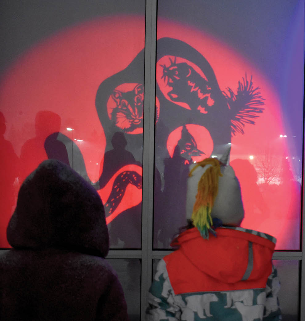 photo of two people looking at colorful image projected on a wall